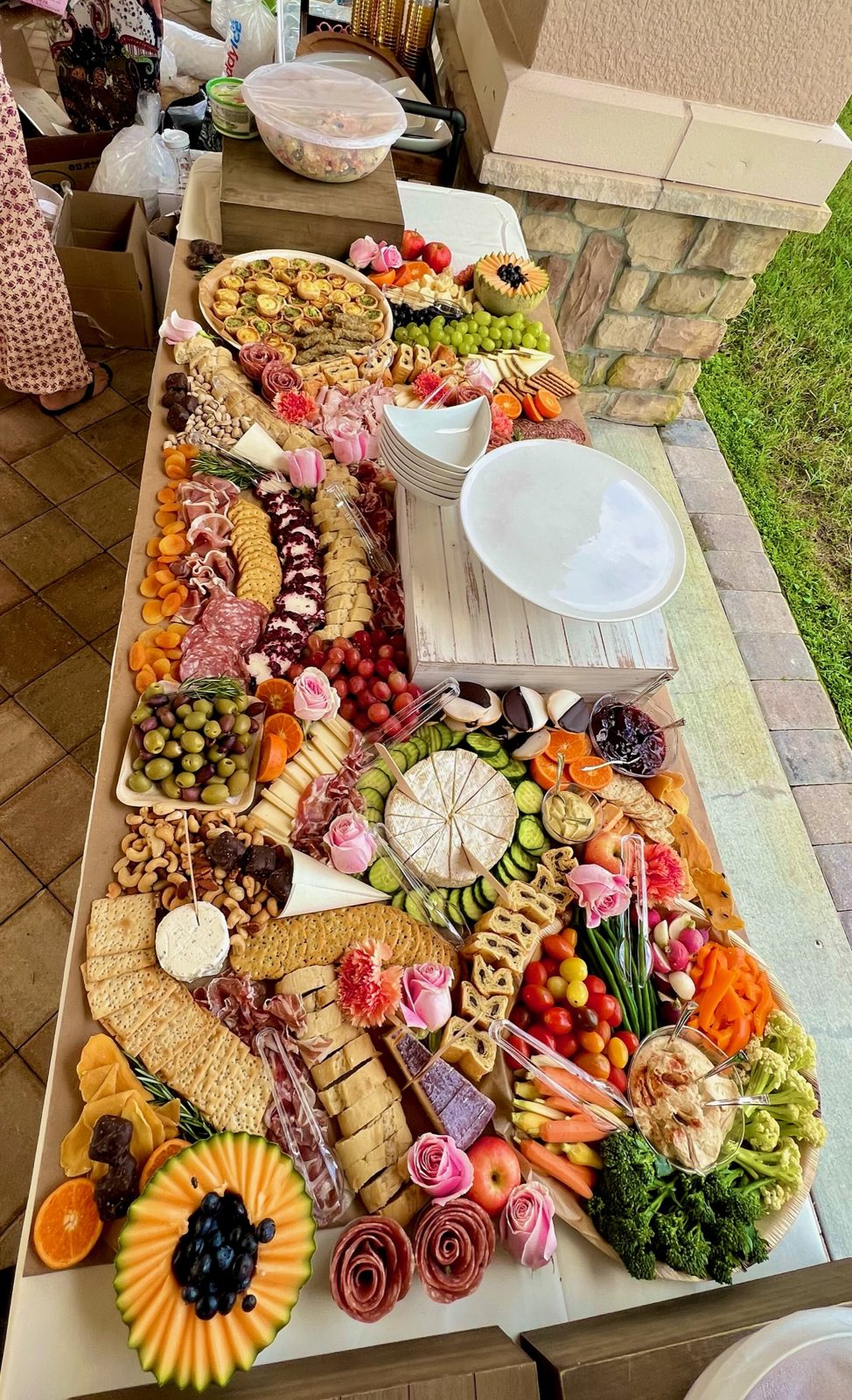 Outdoor grazing table styled with sunflowers and seasonal fruit