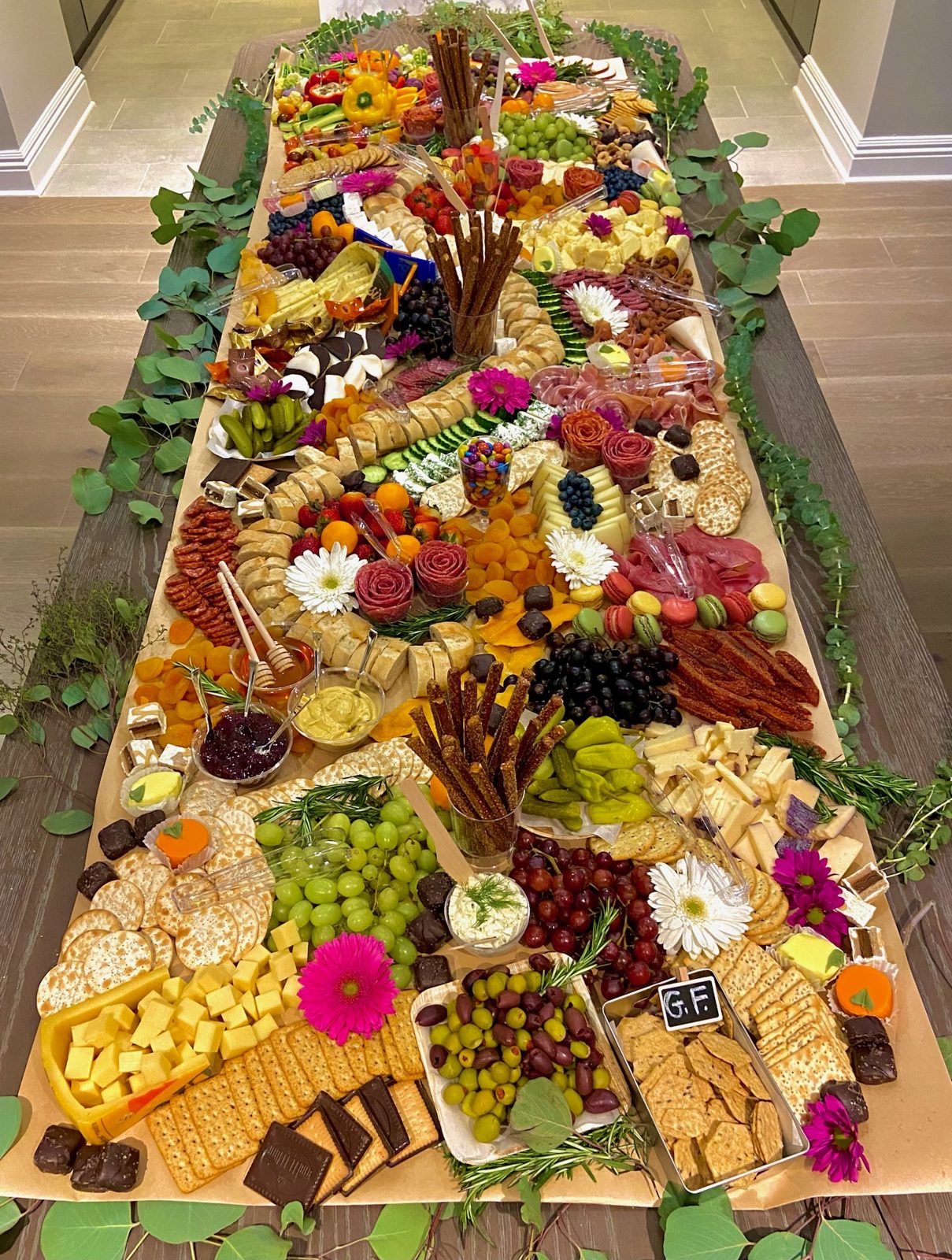 Grazing table running the length of a room with eucalyptus garland